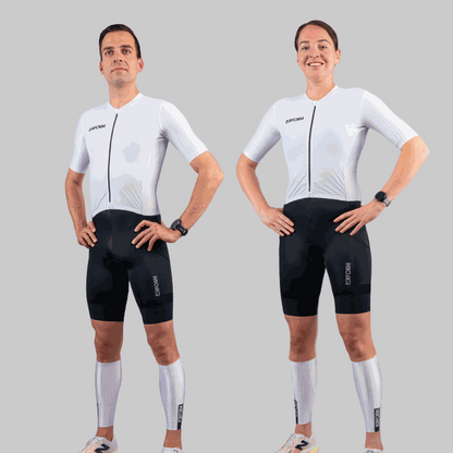 Male and female athletes wearing TechBoost FastSuit triathlon suits with white aero tops and black shorts against gray background