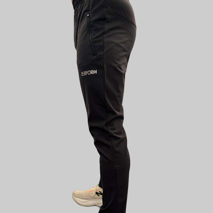 Side view of black Off Duty Casual Pant for men with zip pocket and subtle performance details, worn with white sneakers