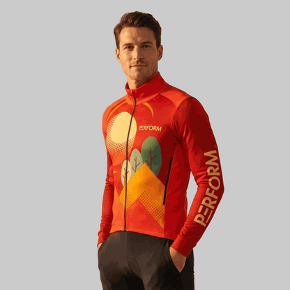 Man wearing TechBoost Aero Jersey LS Sunset Trail with sunset and nature graphic design, aerodynamic fit, and "PERFORM" text on sleeve.